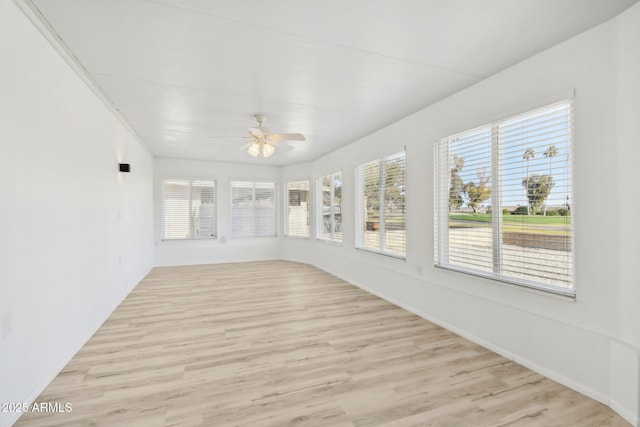 unfurnished sunroom with ceiling fan and a healthy amount of sunlight