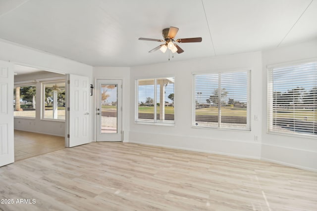 unfurnished sunroom with ceiling fan