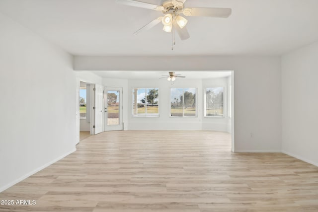 spare room featuring ceiling fan, light hardwood / wood-style flooring, and a healthy amount of sunlight