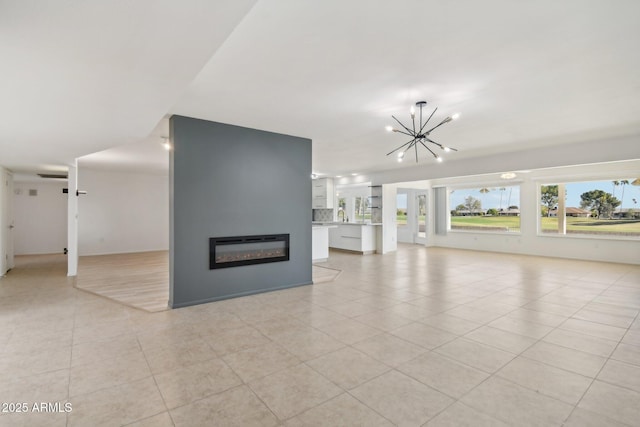 unfurnished living room featuring sink, light tile patterned floors, and a chandelier