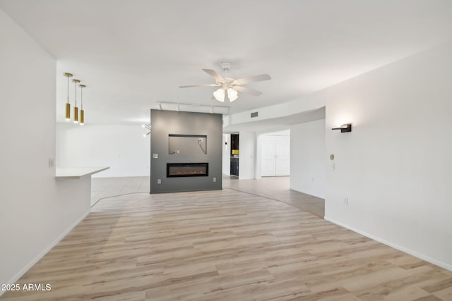 unfurnished living room with ceiling fan and light hardwood / wood-style floors