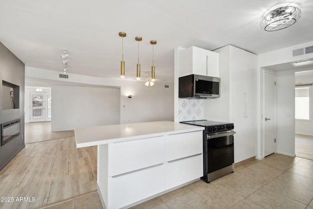 kitchen featuring white cabinetry, ceiling fan, hanging light fixtures, backsplash, and appliances with stainless steel finishes