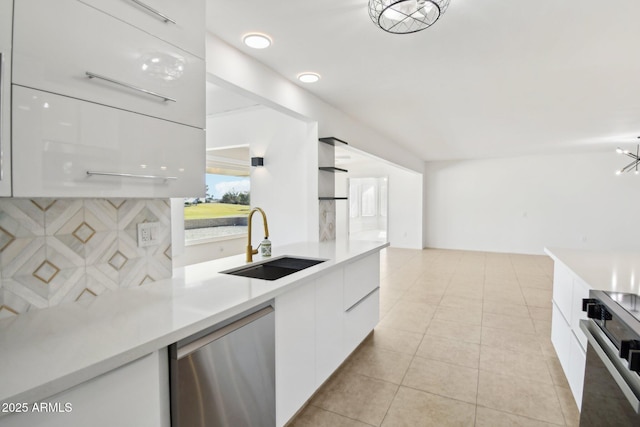 kitchen featuring appliances with stainless steel finishes, sink, a notable chandelier, white cabinets, and light tile patterned flooring