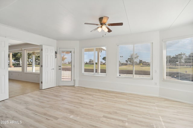 unfurnished sunroom featuring ceiling fan