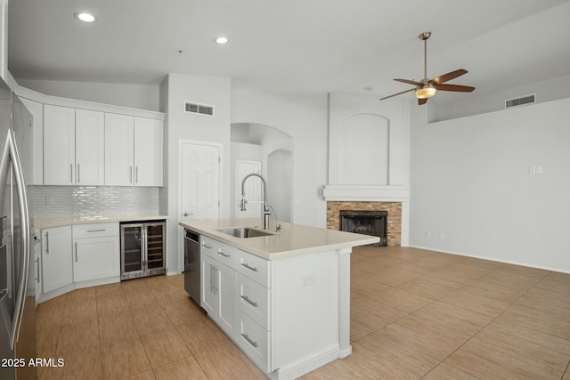 kitchen with wine cooler, visible vents, appliances with stainless steel finishes, and a sink