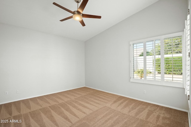 carpeted empty room featuring vaulted ceiling, baseboards, and ceiling fan