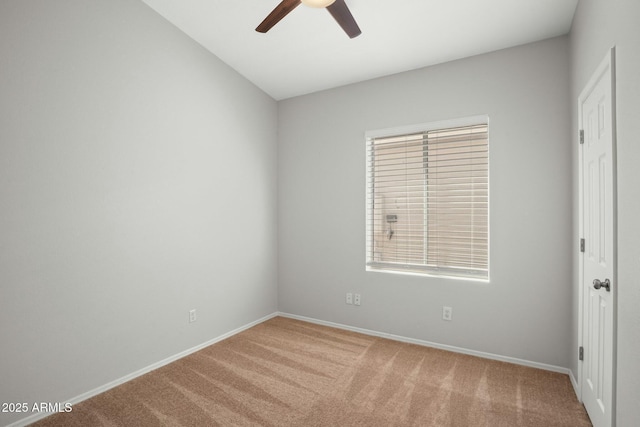 carpeted spare room with baseboards and ceiling fan