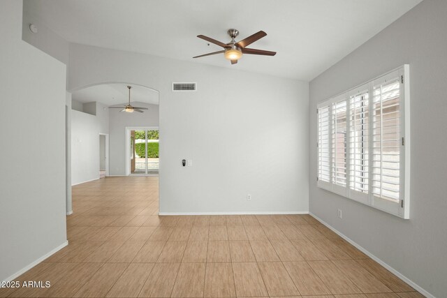 unfurnished room featuring a ceiling fan, visible vents, baseboards, arched walkways, and vaulted ceiling