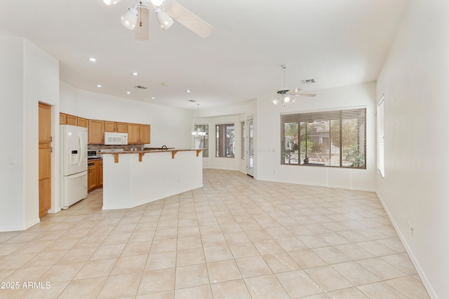 4540 E Mia Ln, Gilbert, AZ 85298 - kitchen with open floor plan, a kitchen bar, white appliances, ceiling fan, and light tile patterned floors