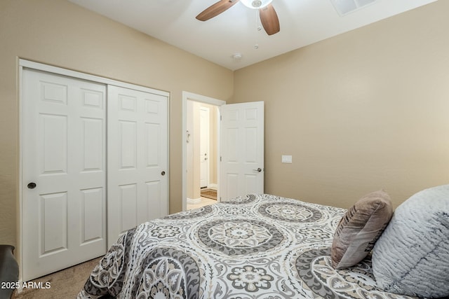 carpeted bedroom with ceiling fan and a closet