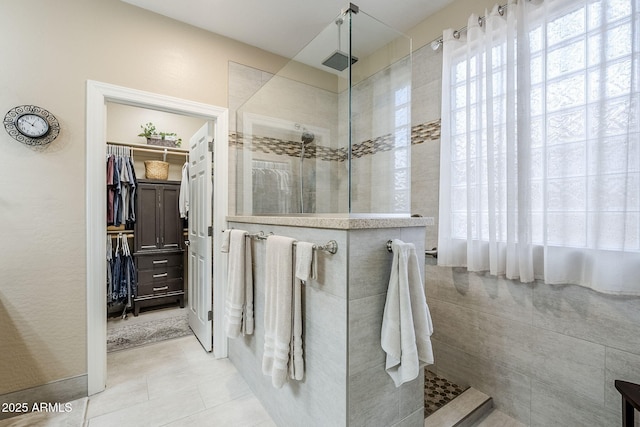 bathroom with tile patterned flooring and tiled shower