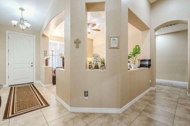 hall with light tile patterned floors and a notable chandelier