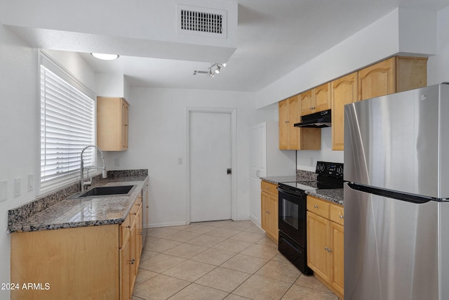 kitchen with stainless steel fridge, black range with electric cooktop, dark stone countertops, and sink