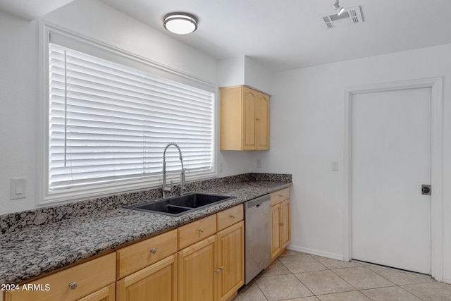 kitchen featuring dishwasher, light brown cabinets, sink, dark stone countertops, and light tile patterned flooring