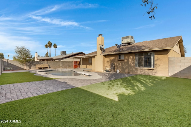 back of house with a fenced in pool, a yard, a patio, and central AC