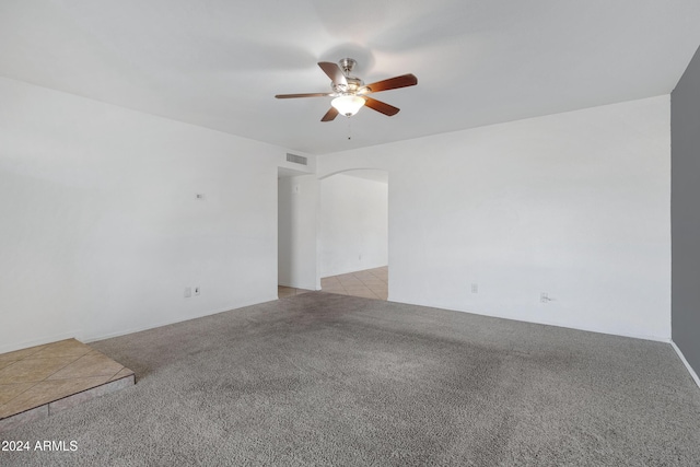 spare room featuring light carpet and ceiling fan