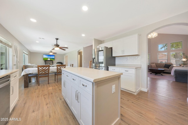 5744 E Jacaranda St, Mesa, AZ 85205 - kitchen with open floor plan, appliances with stainless steel finishes, arched walkways, light wood finished floors, and recessed lighting