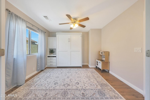 5744 E Jacaranda St, Mesa, AZ 85205 - unfurnished bedroom with wood finished floors and a ceiling fan