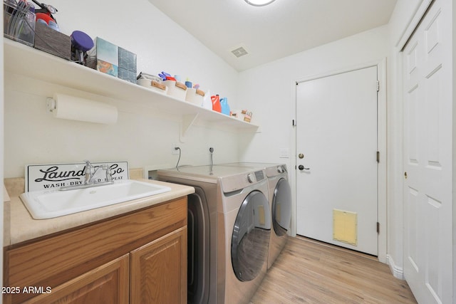 5744 E Jacaranda St, Mesa, AZ 85205 - laundry area with separate washer and dryer, light wood-type flooring, and cabinet space