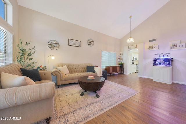 5744 E Jacaranda St, Mesa, AZ 85205 - living room featuring high vaulted ceiling, arched walkways, and wood finished floors