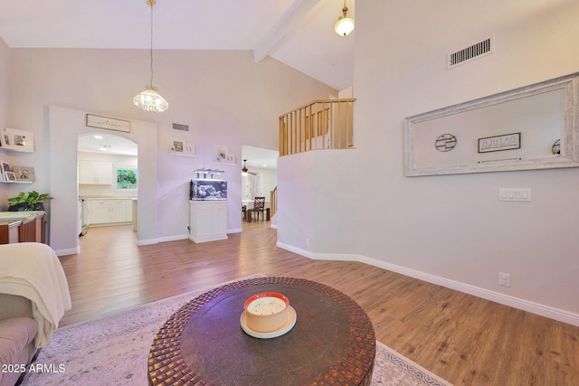 5744 E Jacaranda St, Mesa, AZ 85205 - living room featuring wood finished floors, beam ceiling, arched walkways, and high vaulted ceiling