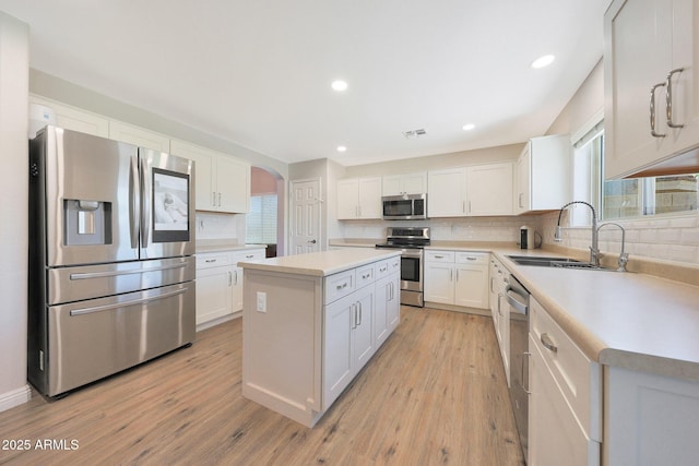 5744 E Jacaranda St, Mesa, AZ 85205 - kitchen featuring stainless steel appliances, a center island, tasteful backsplash, light wood-style floors, and light countertops