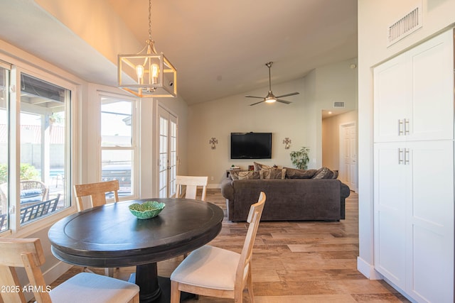 dining room with high vaulted ceiling, a wealth of natural light, visible vents, and light wood-style flooring