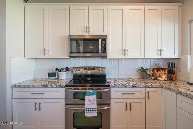 kitchen featuring white cabinets, tasteful backsplash, appliances with stainless steel finishes, and light stone counters