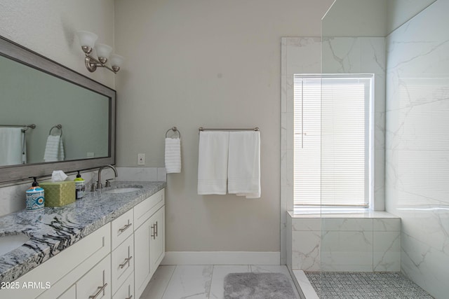 full bath with marble finish floor, baseboards, a sink, and double vanity