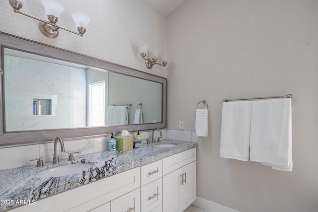 bathroom featuring baseboards, a sink, and double vanity