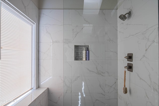 bathroom with a healthy amount of sunlight and a marble finish shower