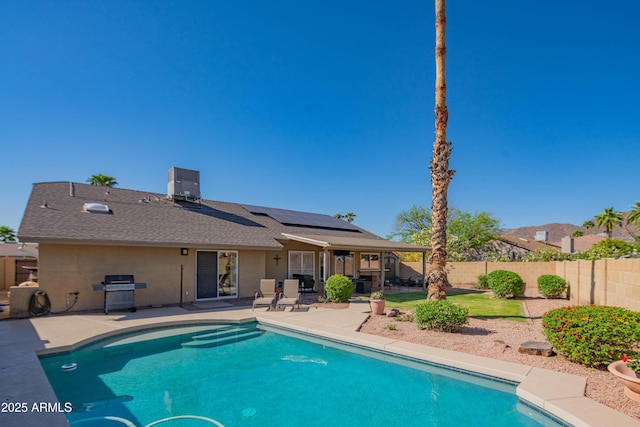view of swimming pool featuring a fenced in pool, a fenced backyard, a grill, central AC, and a patio area