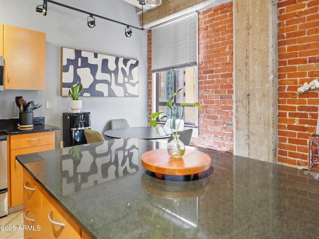 114 W Adams St Unit 505, Phoenix, AZ 85003 - kitchen featuring dark stone countertops, stainless steel microwave, and brick wall