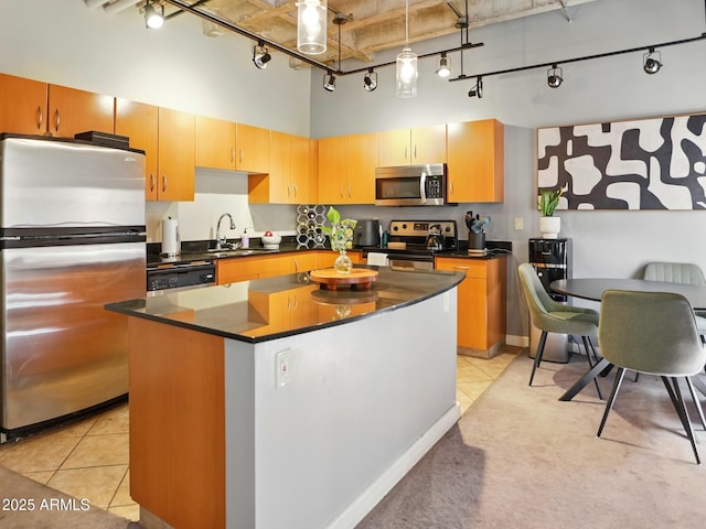 114 W Adams St Unit 505, Phoenix, AZ 85003 - kitchen featuring appliances with stainless steel finishes, rail lighting, a high ceiling, dark countertops, and light tile patterned flooring