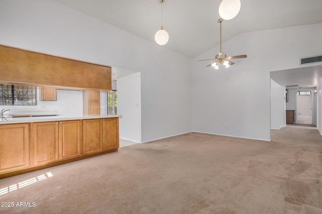 6602 W Ironwood Dr, Glendale, AZ 85302 - unfurnished living room featuring light carpet, a ceiling fan, healthy amount of natural light, high vaulted ceiling, and baseboards