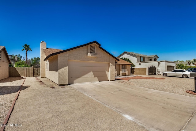 6602 W Ironwood Dr, Glendale, AZ 85302 - view of front of house featuring a garage, driveway, a chimney, and stucco siding