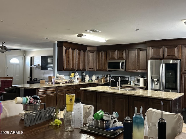 kitchen featuring sink, dark brown cabinets, an island with sink, and appliances with stainless steel finishes