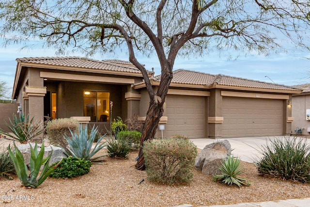 view of front of house with a garage, driveway, and stucco siding