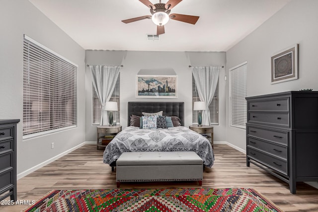 bedroom with baseboards, visible vents, and light wood finished floors