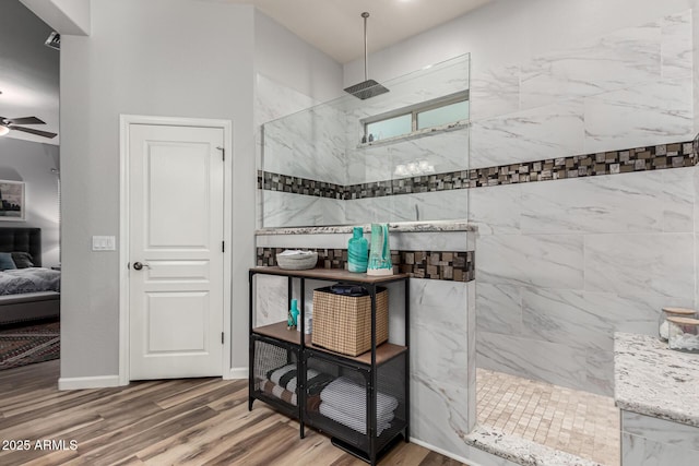 ensuite bathroom with baseboards, a ceiling fan, connected bathroom, wood finished floors, and walk in shower