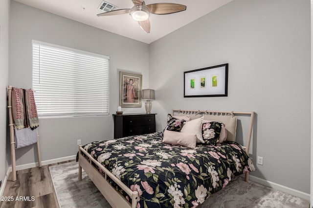 bedroom with visible vents, ceiling fan, baseboards, and wood finished floors