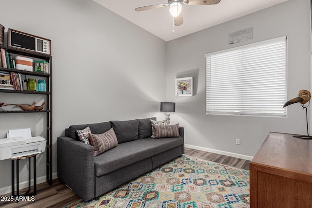 living room with wood finished floors, a ceiling fan, and baseboards