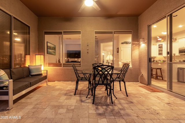 dining space with stone tile floors and ceiling fan