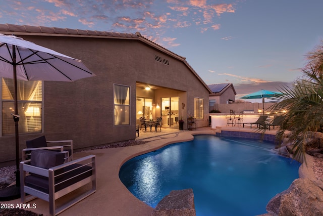 pool at dusk featuring a patio, fence, and a fenced in pool