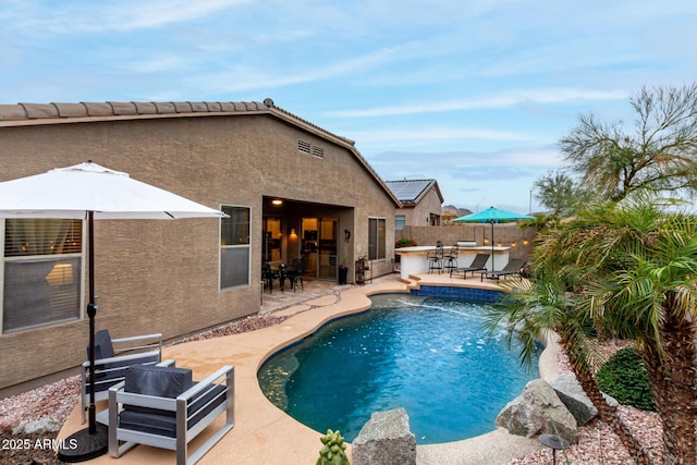 view of swimming pool featuring a fenced in pool, a patio, outdoor dry bar, and fence