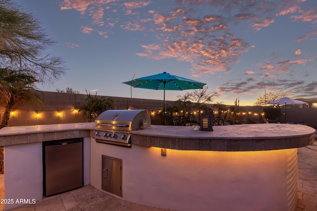 view of patio / terrace with area for grilling and fence