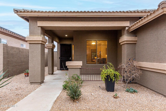 doorway to property with fence and stucco siding