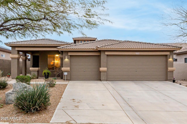 prairie-style home with a porch, a garage, concrete driveway, a tiled roof, and stucco siding