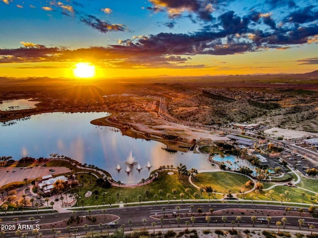 aerial view at dusk featuring a water view