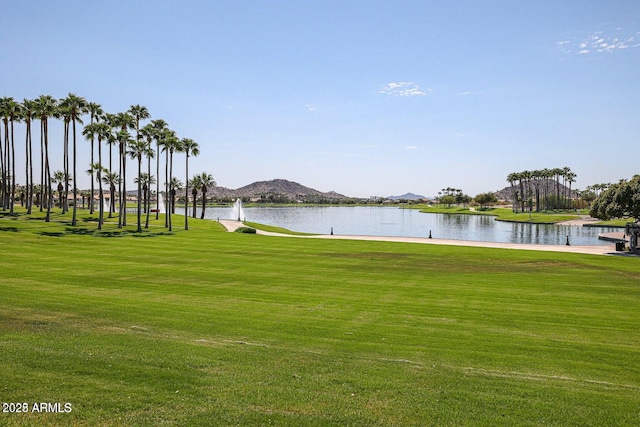 exterior space featuring a lawn and a water and mountain view